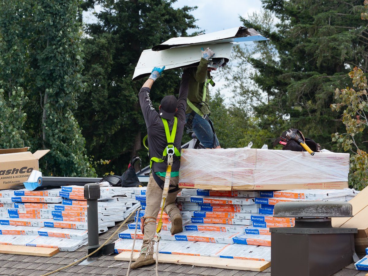 Liberty in-house crew installing flashing on a roof with CertainTeed shingles staged